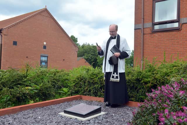 Father Kyle McNeil blessing the commemorative plaque.