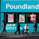 Shoppers walk past a Poundland shop in Brixton, south London.