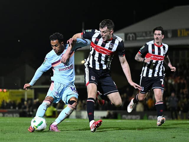 Fabio Carvalho of Brentford shoots as Sam Lavelle of Grimsby Town challenges.