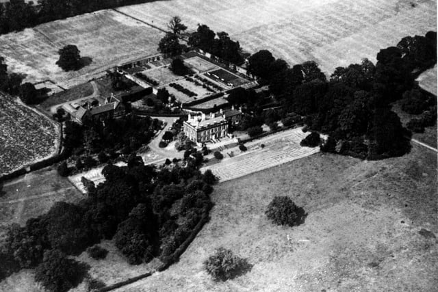 An aerial view looking north east over the Barrowby Hall Estate off Barrowby Lane. The area is surrounded by fields.