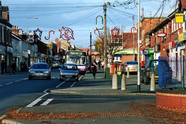 Main Street showing the junction with Greensway in the foreground. Shops visible include HSBC Bank and Mike Dobson's estate agents, Emsley's solicitors and estate agents, a chemist, a post office and a Co-op store on the right.