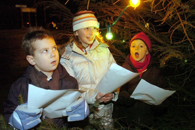 Joe, Rosie and Max singing carols at the Kirkhamgate Christmas tree in the centre of the village near Wakefield