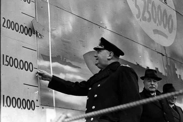 Admiral Sir Thomas Spence Lyne moves the target indicator to open Ark Royal Week in January 1942. This was located outside Leeds Town Hall on Victoria Square.