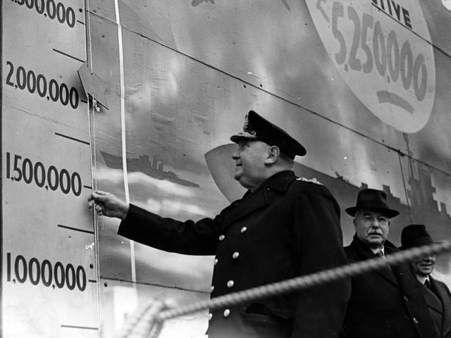 Admiral Sir Thomas Spence Lyne moves the target indicator to open Ark Royal Week in January 1942. This was located outside Leeds Town Hall on Victoria Square.