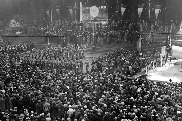 Dense crowds outside Leeds Town Hall, in front of the steps are ranked servicemen and women. On the platform is General De Gaulle, who had been invited to make a speech and move the target indicator.