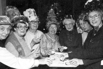 December 1984 and a group of ladies in party hats enjoying mince pies at the Epiphany Lunch Club Christmas Dinner held in the Epiphany Hall of the Church of the Epiphany on Beech Lane.