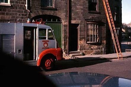 The Herb Shop in the Market Place was the scene of a fire in 1967. The fire engine has been summoned and ladders are in use. The new fire station was opened in 1958 at the end of Victoria Street and Walton Road.