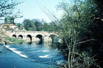The River Wharfe looking from the top of the weir towards Wetherby Bridge. Taken in the summer of 1962, the image shows gasometers in the background.