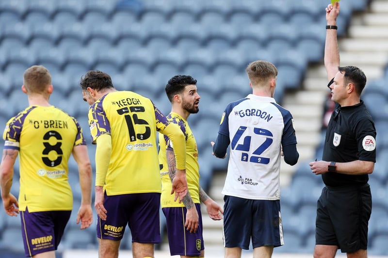 Referee James Linington shows the yellow card to PNE winger Anthony Gordon and Huddersfield's Pipa