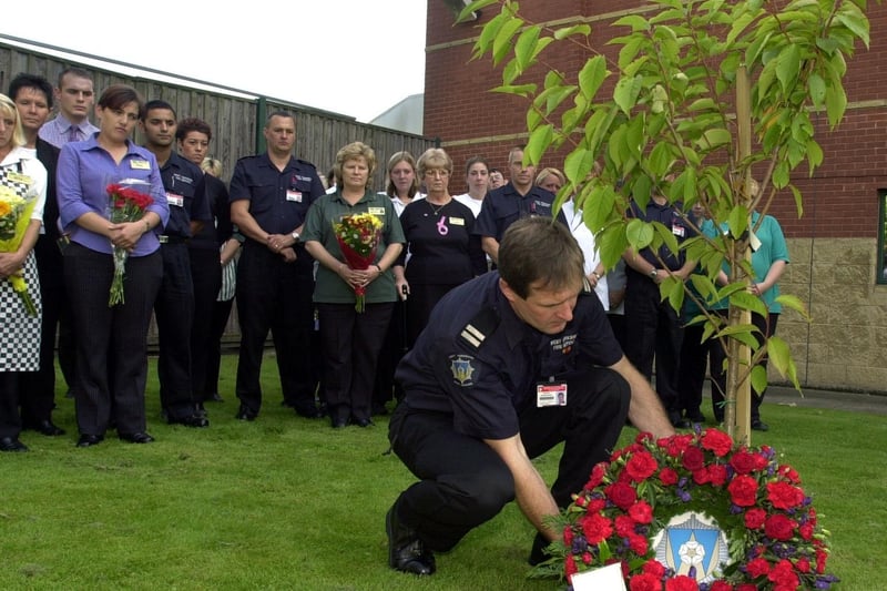 September 2002 and Sub Officer Stephen Wolstenholme (Pudsey Fire Station) lays a wreath at the memorial tree at ASDA Owlcotes planted as a mark of respect following the World Trade Centre tragedy.