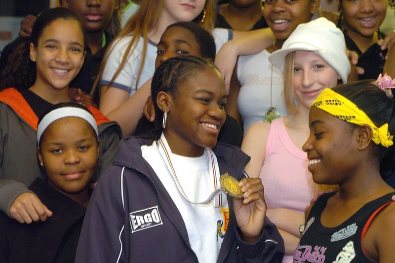 December 2004 and boxer and former pupil Nicola Adams shows the gold medal she won as English amateur champion on a visit to the school.