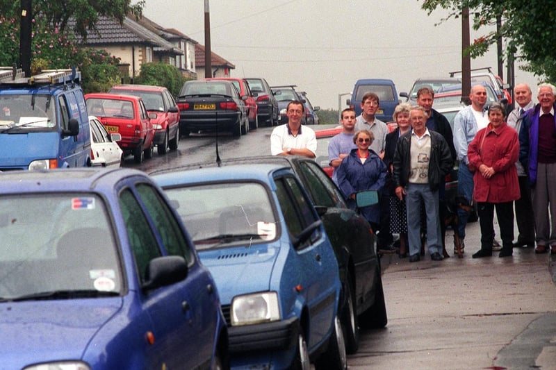 Residents of Haigh Wood Road surrounded by cars.
