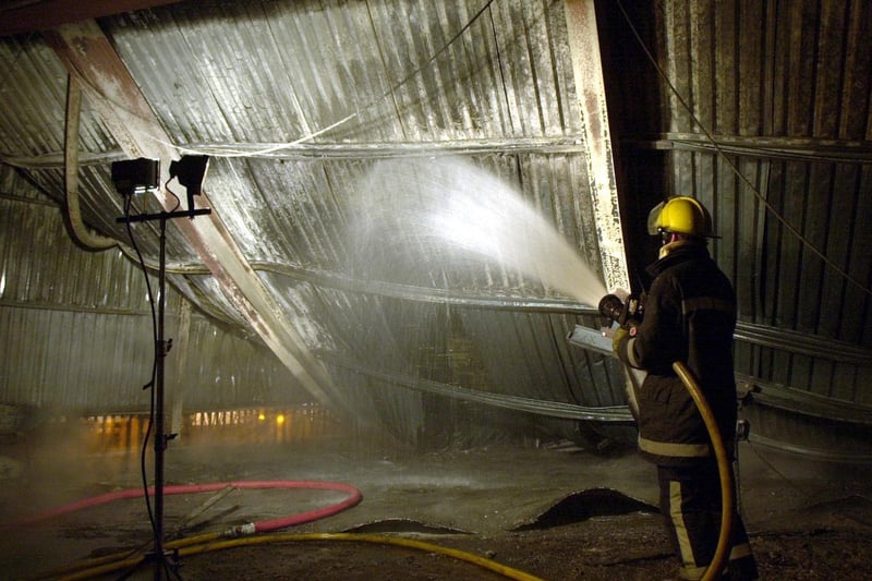 A firefighter dampens down at the Greggs Bakery warehouse at Elmfield Way in Bramley after a blaze in March 2000.