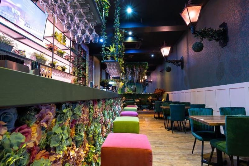 Velour chairs and floral wall art decorate the interior of the new restaurant