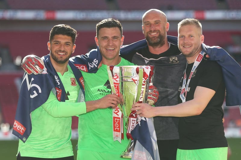Morecambe's Kyle Letheren, Mark Halstead, Andre Mendes and Barry Roche with the trophy (Photo: Rob Newell/CameraSport)