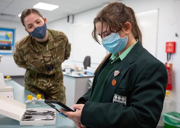 A team from RAF Wittering guides staff at Bourne Grammer School in Coronavirus testing for students and staff., pictured is  SAC K Coleman helping a pupil with NHS registration.