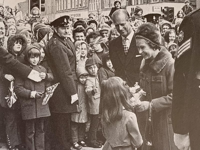 The Queen is presented with flowers by Julie Swift.