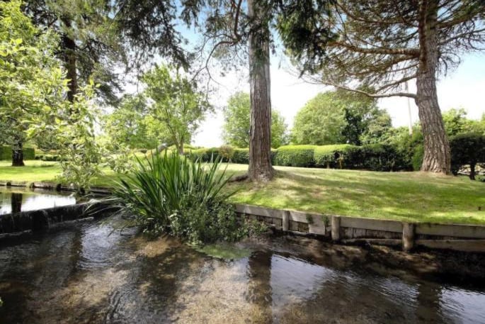 The gardens and grounds are beautifully landscaped and are bounded by a pretty stream to the rear. The principal lawns are interspersed with very well stocked floral beds, framed by box hedging.