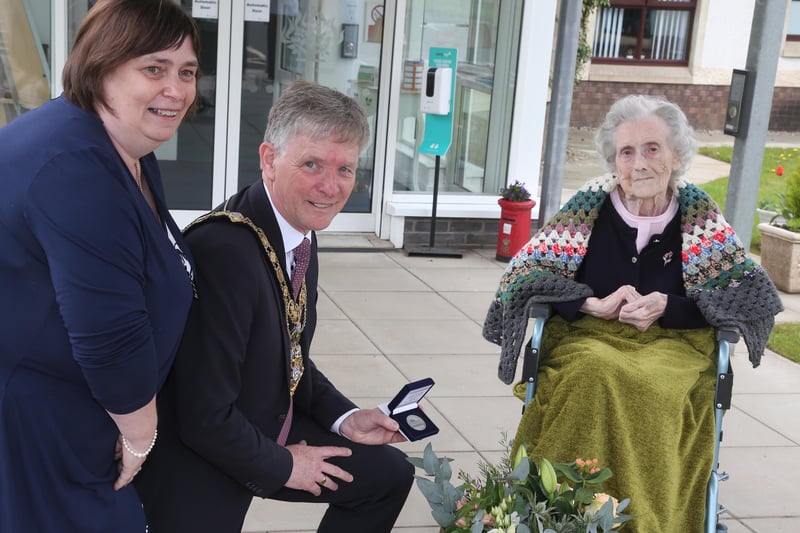 Christina McMullan, who celebrated her 100th birthday on January 23, receives her NI 100 commemorative coin from the Mayor of Causeway Coast and Glens Borough Council Alderman Mark Fielding and Mayoress Mrs Phyllis Fielding