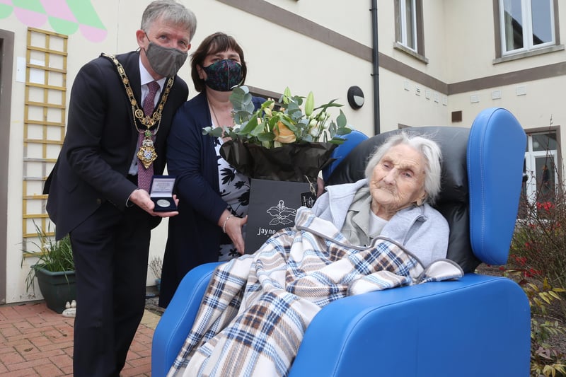 Sarah Wilson receives her NI 100 commemorative coin to mark her 100th birthday from the Mayor of Causeway Coast and Glens Borough Council Alderman Mark Fielding and Mayoress Mrs Phyllis Fielding