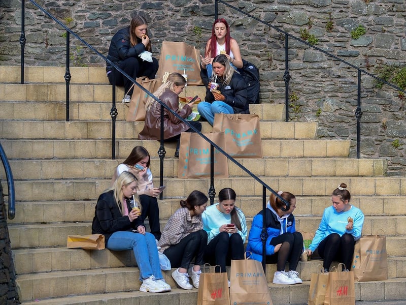 Taking a break from shopping on Friday morning as non-essential retails outlets reopened. Photo: George Sweeney / Derry Journal. DER2117GS - 037