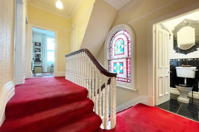 The first floor landing impresses with its stained glass sash window.