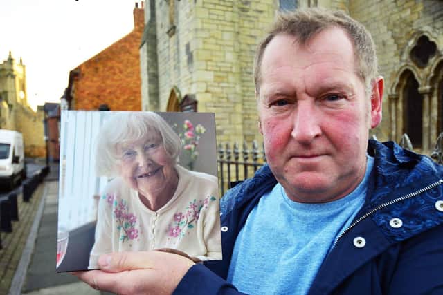 Patrick O'Dell outside St Mary's Catholic Church, with a photograph of his late mum Doris. Picture by FRANK REID