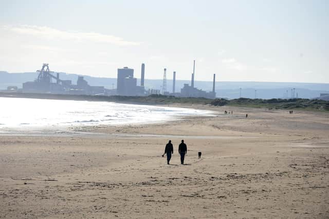 Dog walkers on the beach at Seaton Carew seafront.