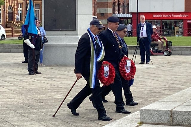 Wreaths are carried to the war memorial in Victory Square during the event on Tuesday. Picture by FRANk REID
