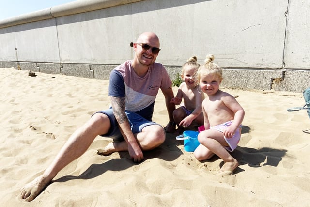 Ross Metcalf with his daughters Phoebe and Lucy playing on the beach. Picture by FRANK REID beach