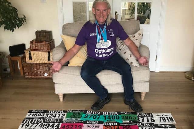 Phil Holbrook with a collection of his Great North Run numbers and medals from previous years.