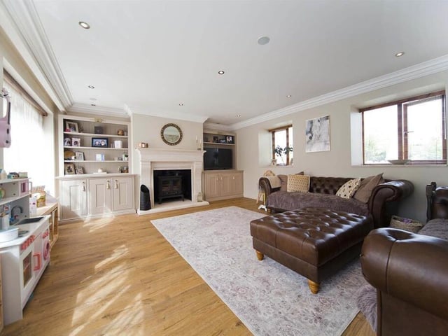 This separate sitting room has a log and coal-burning stove and large arched barn-style windows.