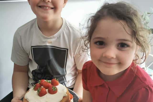 Scarlett, 5, and Riley Robinson, 8, with their strawberry and cream cake that they made during a Cake Ninja webinar.
