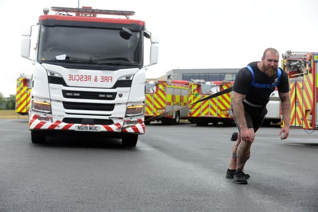 Bodybuilder Adam Marshall prepares to pull a fire appliance on Miles for Men's fundraising day.