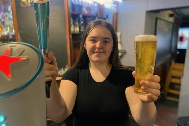 Chloe Rutherford holds one of the last pints to be pulled at the Hope and Anchor Pub.