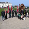 Regimental standard bearers with Mick Lynch, Headquarters Royal Yorkshire Regiment, and Lee Bullivant in his regimental colours of the Prince of Wales's Own Regiment of Yorkshire on his trike in front of the Tommy statue, in Terrace Green, Seaham.