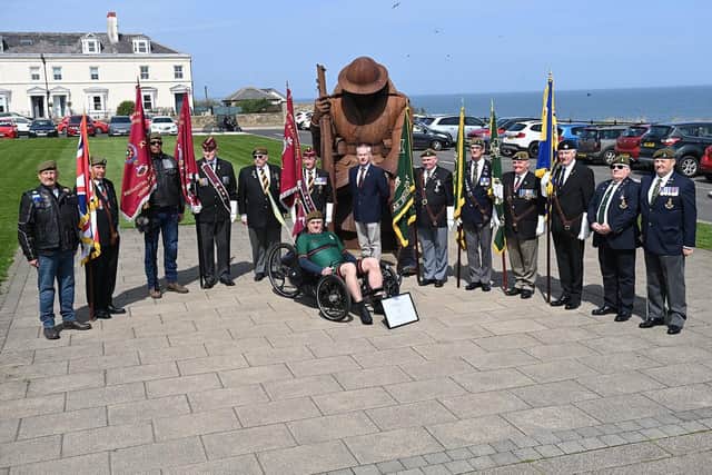 Regimental standard bearers with Mick Lynch, Headquarters Royal Yorkshire Regiment, and Lee Bullivant in his regimental colours of the Prince of Wales's Own Regiment of Yorkshire on his trike in front of the Tommy statue, in Terrace Green, Seaham.