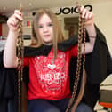 Eight-year-old Ella Kitching from Shotton having her hair cut by Edele Loughran for charity.