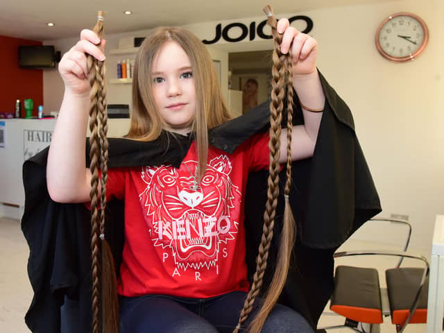 Eight-year-old Ella Kitching from Shotton having her hair cut by Edele Loughran for charity.