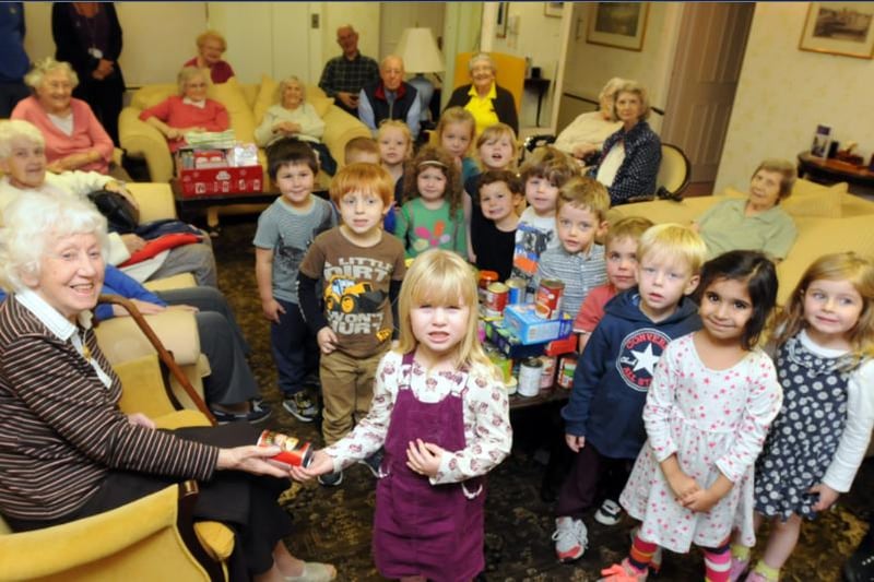 Children from Busybees Nursery brought food for residents and did a sing-a-long at Malvern Court home in 2014. Youngster Eleanor Thorley and resident Rita Sellick are pictured in the foreground.