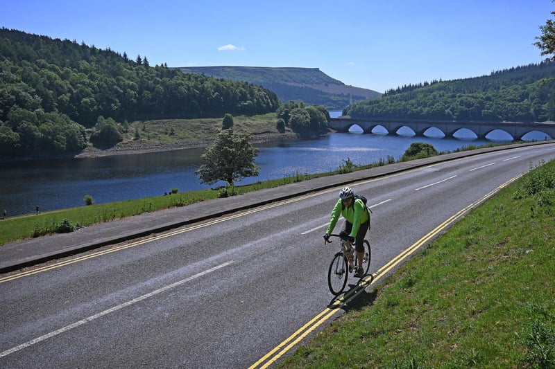 With rolling hills, magnificent moors and a whole host of brilliant towns and villages scattered throughout the Peak District, it is easy to see why it is such a popular destination for tourists to visit.  Pictured is a cyclist riding along the banks of Ladybower Reservoir near Bamford in the Peak District National Park (Photo by PAUL ELLIS/AFP via Getty Images)