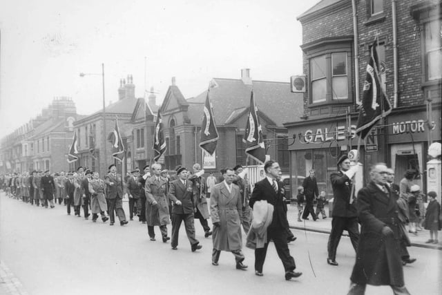A parade makes its way along York Road passing the library, Northern cinema and Gales Garage.