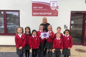 Special educational needs co-ordinator Natalie Boagey is pictured with West View Primary School pupils as they proudly display the school's new Centre of Excellence Award.
