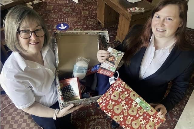 Funeral service arrangers Julia Masshedar and Corina Callan with a shoebox for Operation Christmas Child.