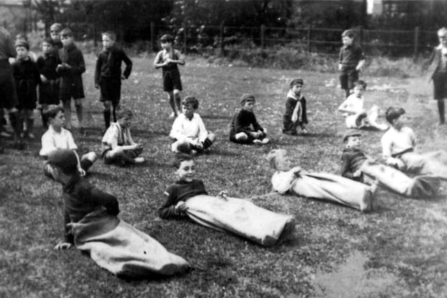 Scout members prepare for a sack race. Date unknown.
