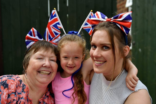 Isla Llyones gets cuddles from Valerie Evans, left, and Jessika Gott at the Trentbrooke Avenue Coronation party.