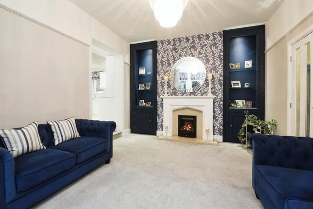 This cosy family room has a fireplace, storage and display units.