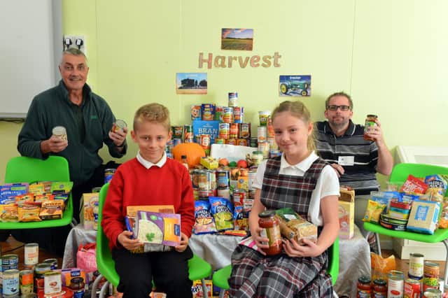 St Helen's Primary School headboy Daniel Owen and headgirl Poppy Barnes with Harvest food donations, which were collected by Hartlepool Food Bank workers Paul Anderson and Dave Tindall, left.