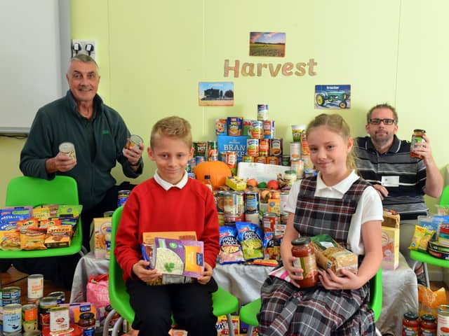 St Helen's Primary School headboy Daniel Owen and headgirl Poppy Barnes with Harvest food donations, which were collected by Hartlepool Food Bank workers Paul Anderson and Dave Tindall, left.
