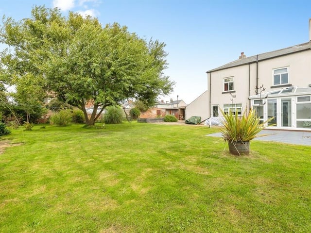 The back garden has a patio area, large lawn and raised allotment section.
